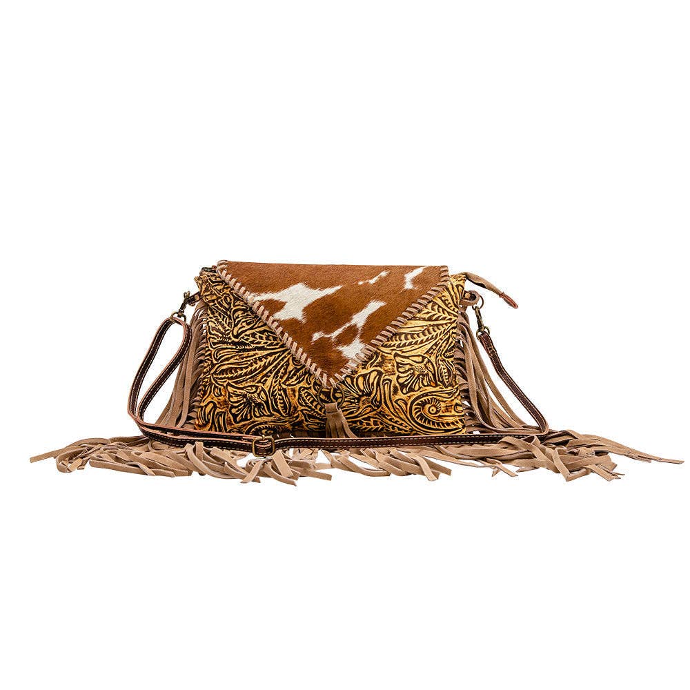Leather and hairon bag featuring a textured design, tan color, and fringed detailing, perfect for Western-style outfits.