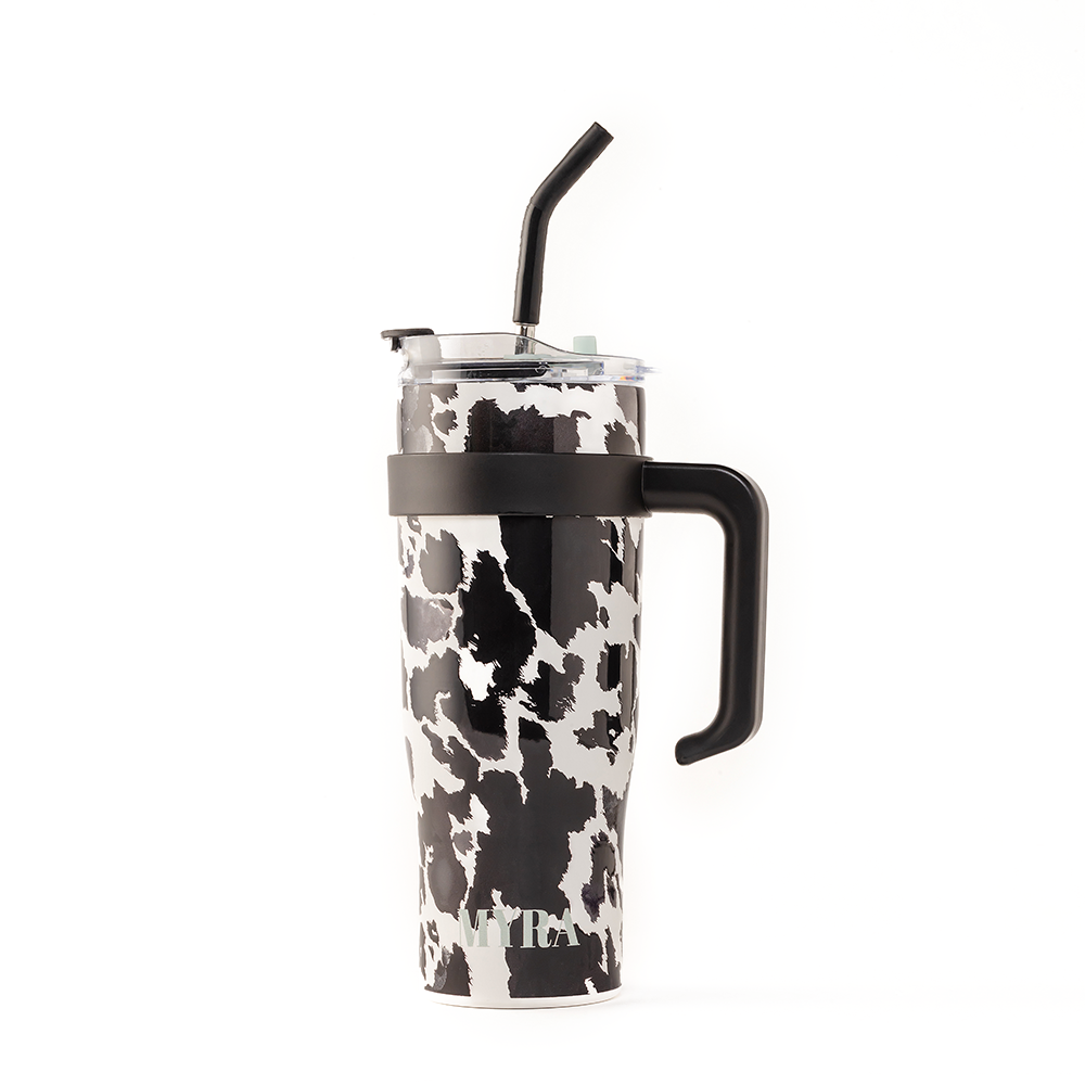 Wide Wyoming Tumbler in black and white featuring a cowhide print, ergonomic handle, and spill-resistant lid.