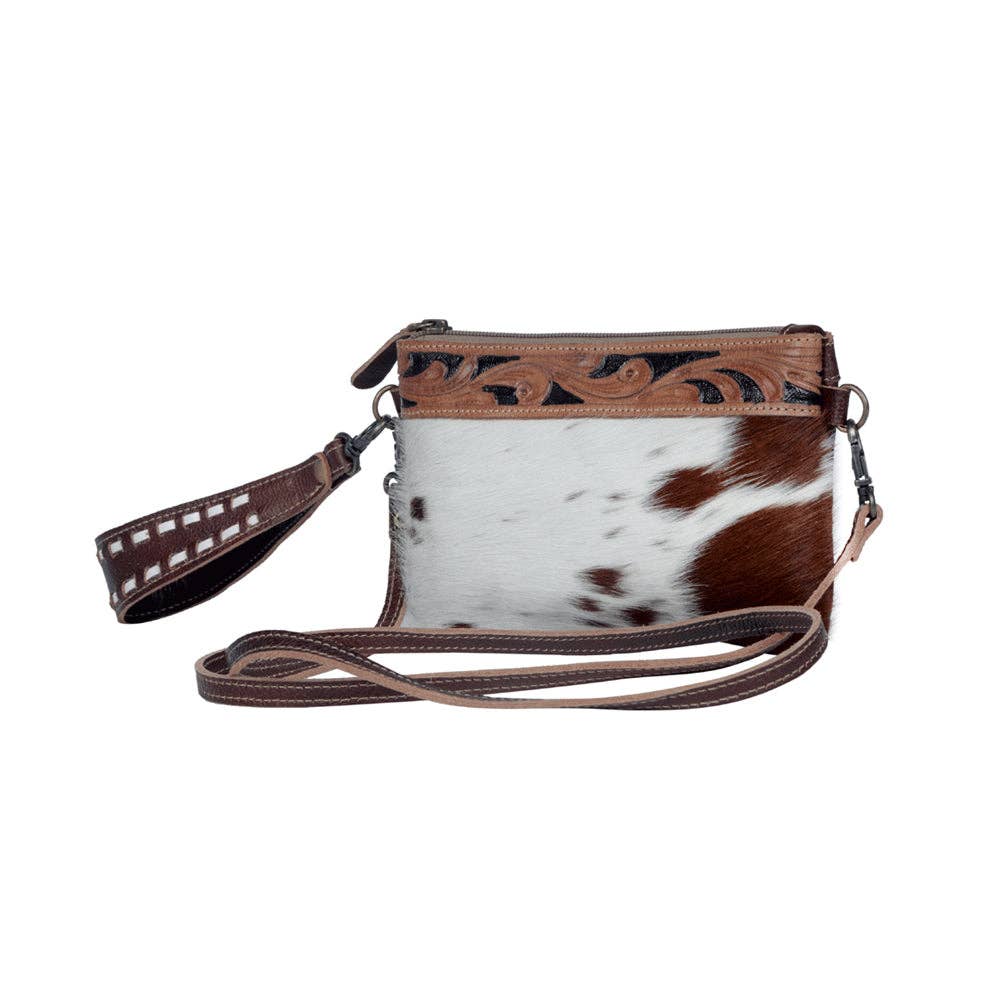 Chic hairon leather belt bag featuring a unique brown and white pattern, hand-tooled detailing, and dual straps.