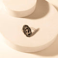 Adjustable Myra Outlaw Hide ring featuring a black and white cowhide pattern set in a textured zinc alloy frame.