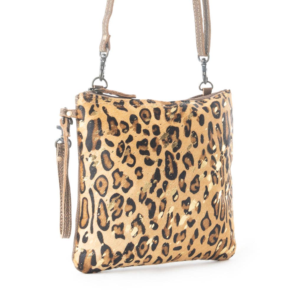 Leopard print bag with gold speckles, made of leather and hairon, featuring a shoulder strap and wristlet handle.