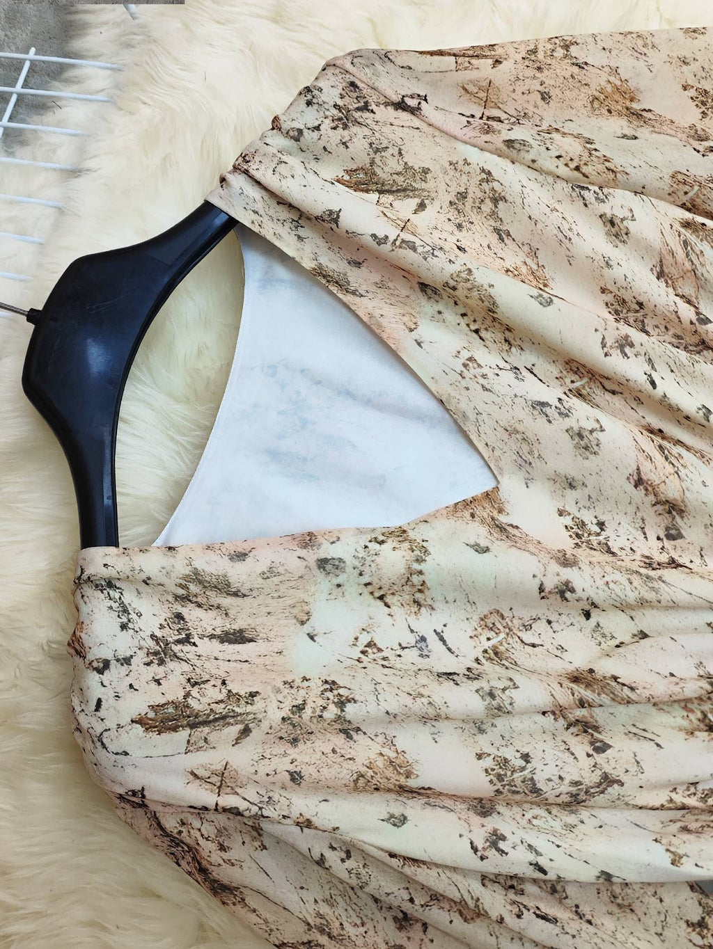 V-neck bohemian layered dress with floral print in soft peach tones, featuring a flowing design and textured fabric.