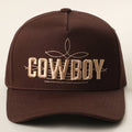 Brown two-tone trucker hat featuring a bold "COWBOY" 3D embroidered design and subtle rope-style accents.