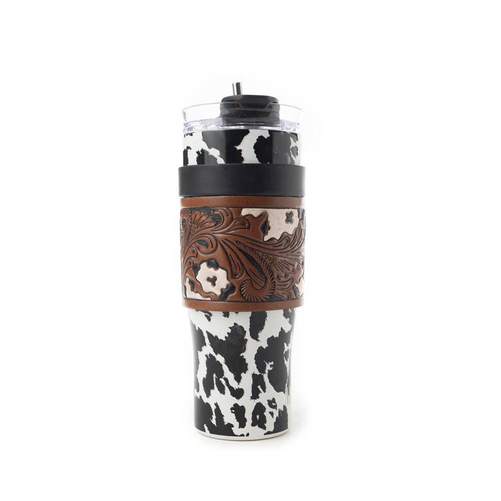 Wide Wyoming Tumbler in black and white featuring a cowhide print, chocolate brown tooled leather wrap, and ergonomic handle.