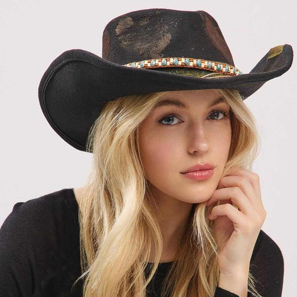 Young woman wearing vintage versatile shapeable cowgirl and fedora hat with distressed fabric band and decorative bow