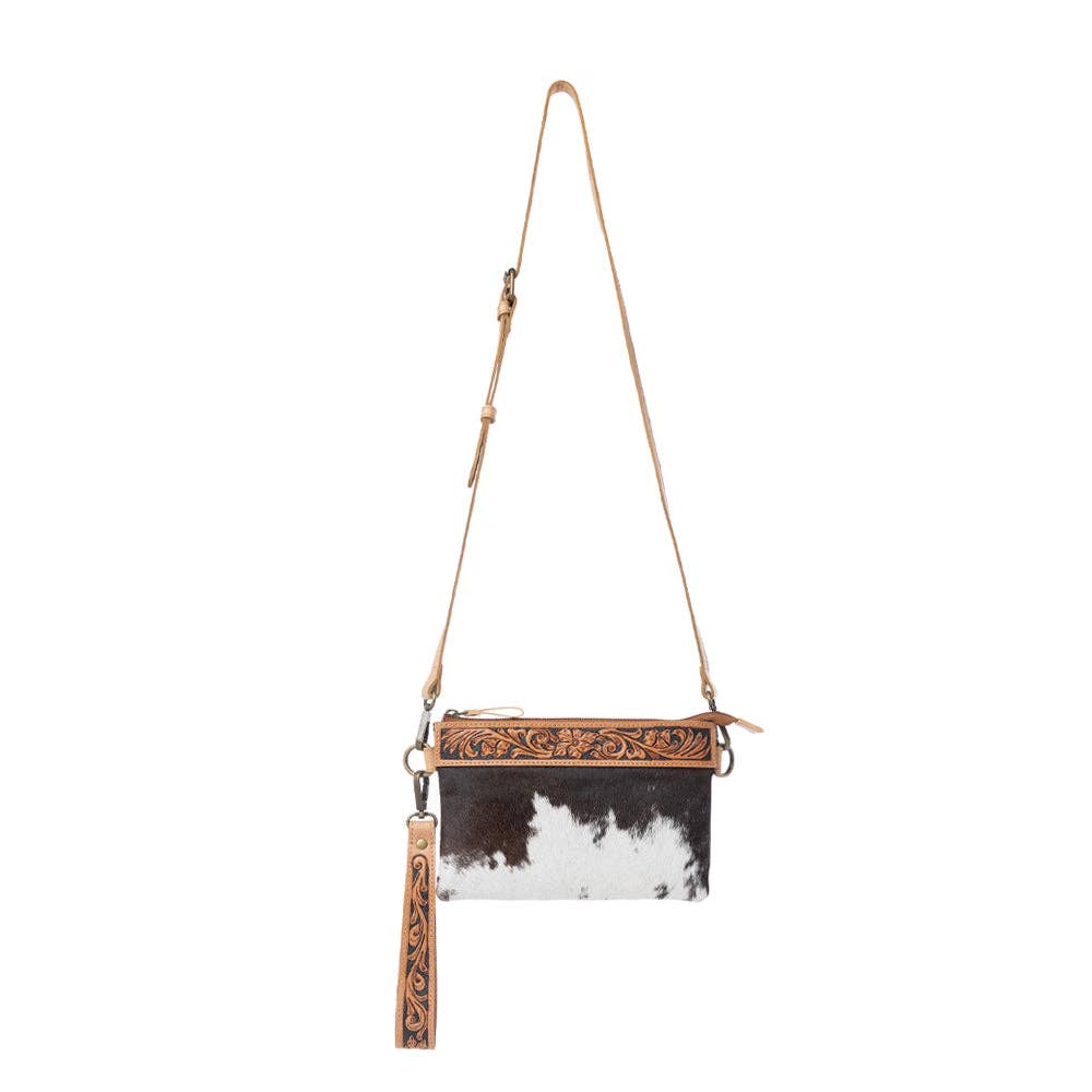 Compact ochre frost leather bag featuring hand-tooled trim and natural hairon panels, with detachable wristlet and adjustable strap.