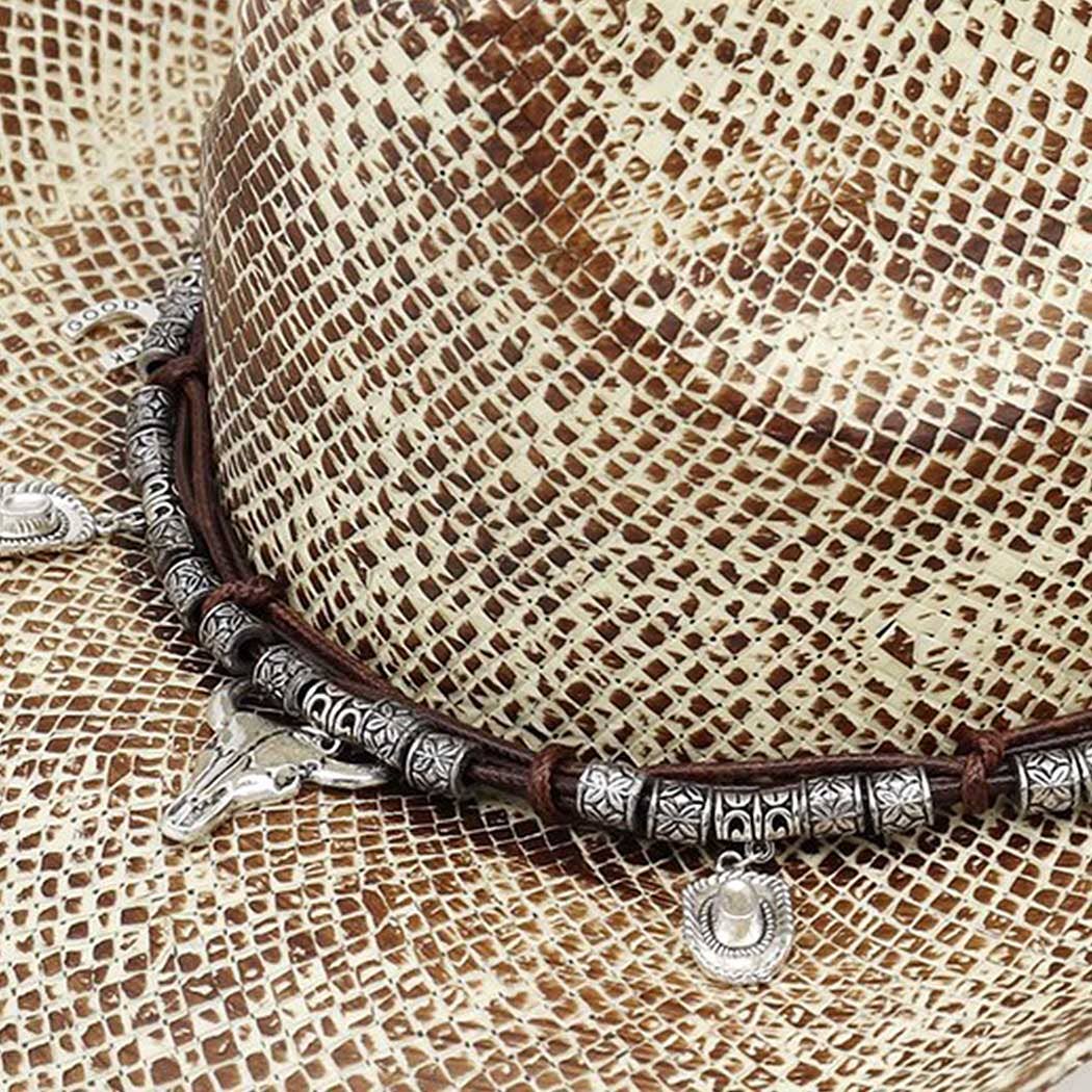 Handmade vintage cowboy hat featuring a textured woven design in light brown, accented with Western-themed charms.