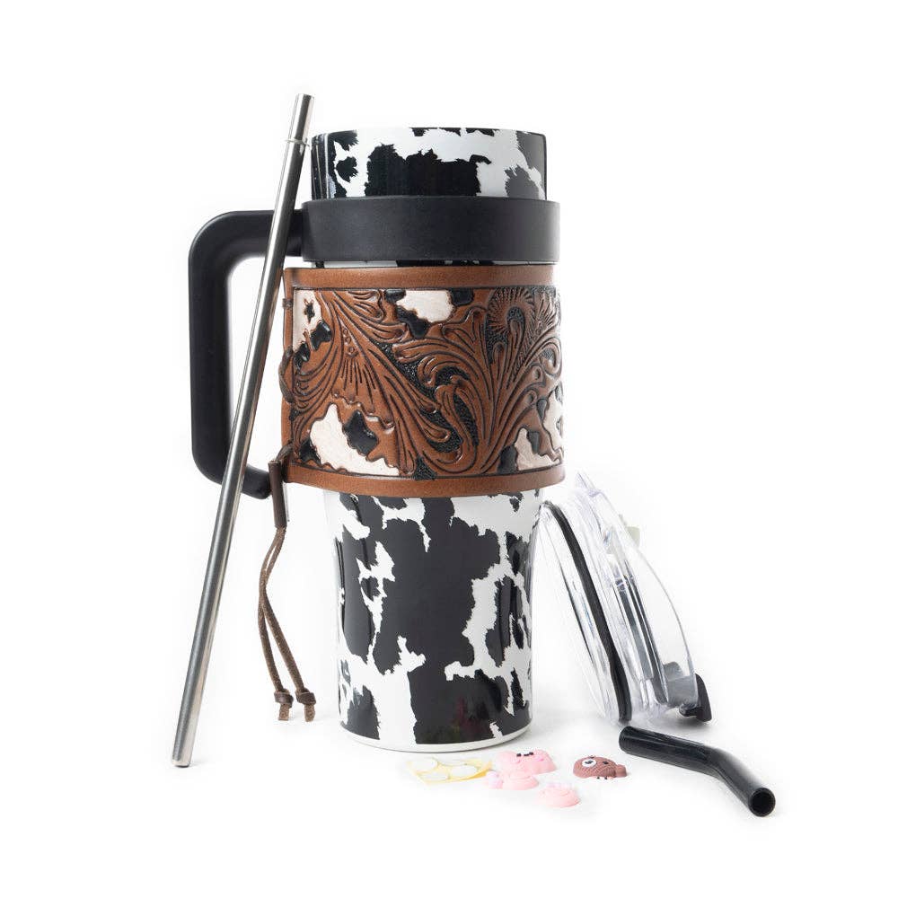 Wide Wyoming Tumbler featuring a bold black and white cowhide print, accented with tooled leather and a robust ergonomic handle.