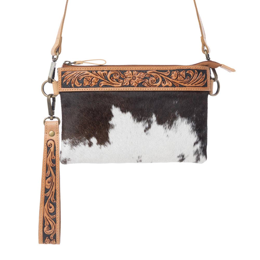 Compact leather bag featuring a textured black and white hairon pattern, with hand-tooled floral detailing on the top trim.