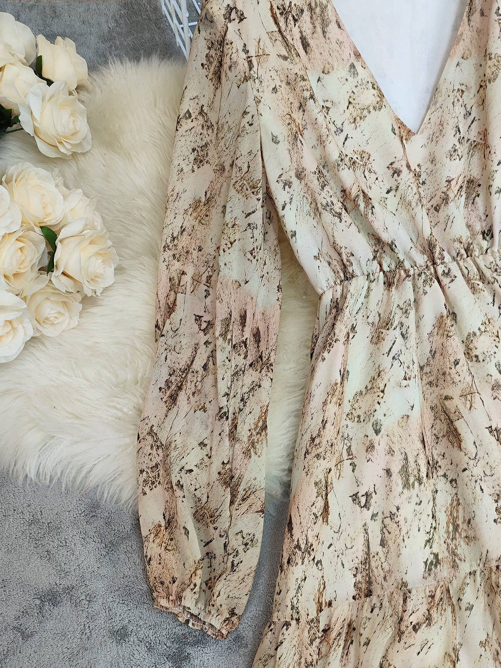 V-neck bohemian layered dress with floral print in soft pastel tones and puff sleeves, featuring an elastic waistband.