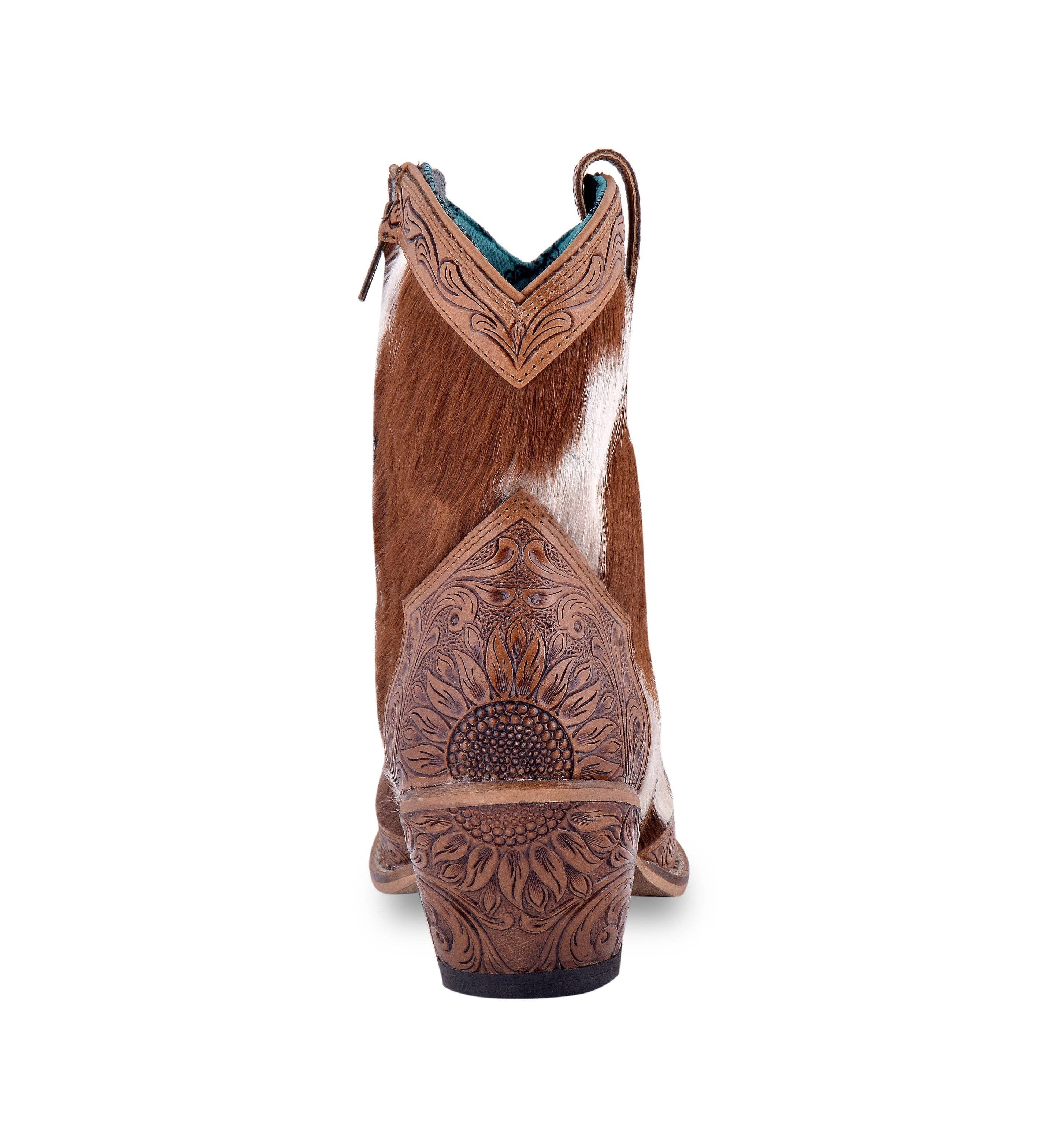 Hair-on hide and hand-tooled leather boots with snip toe, 7" shaft, and a decorative floral design on the heel.