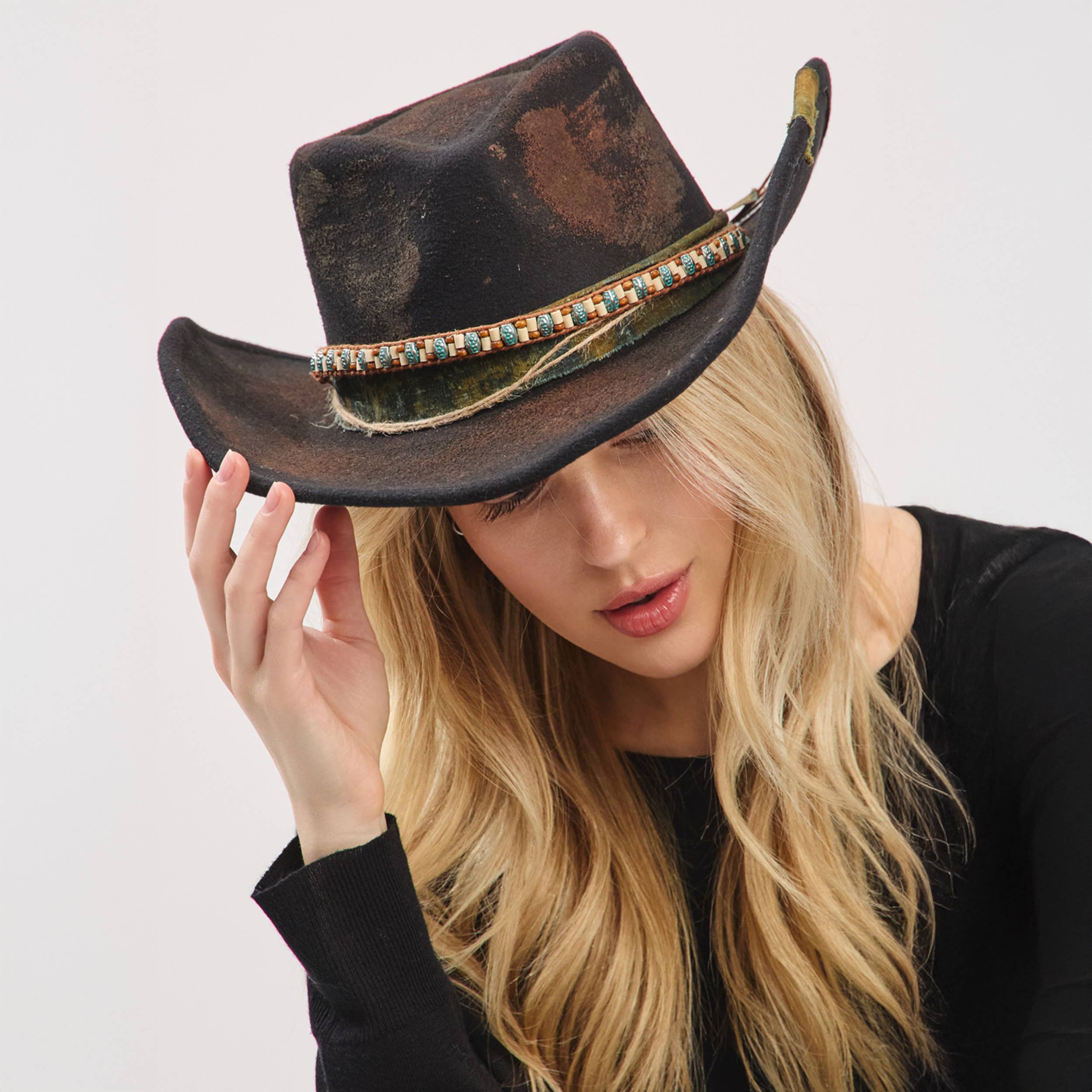 Distressed black cowgirl fedora hat with a shapeable brim and a rustic fabric band featuring turquoise accents.