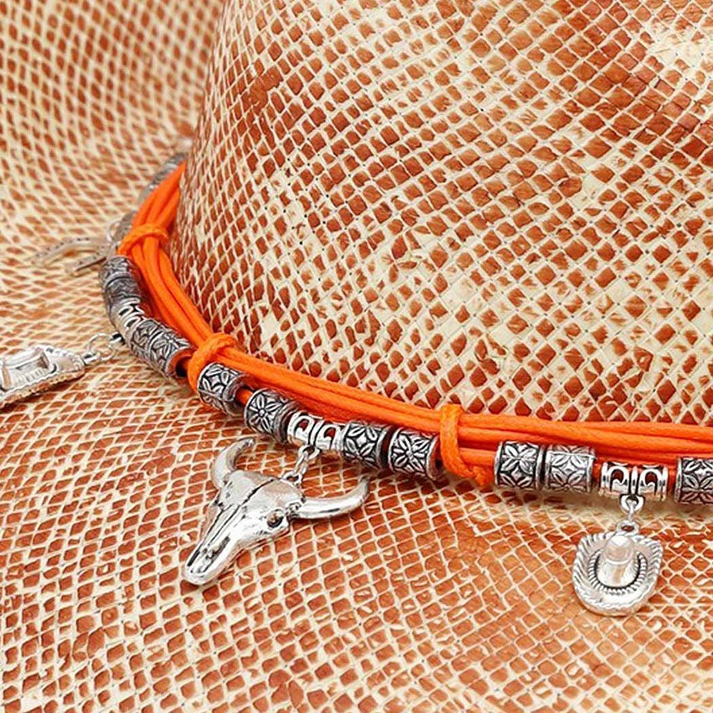 Handmade vintage cowboy hat with a textured woven finish, featuring a band adorned with silver western charms and orange accents.