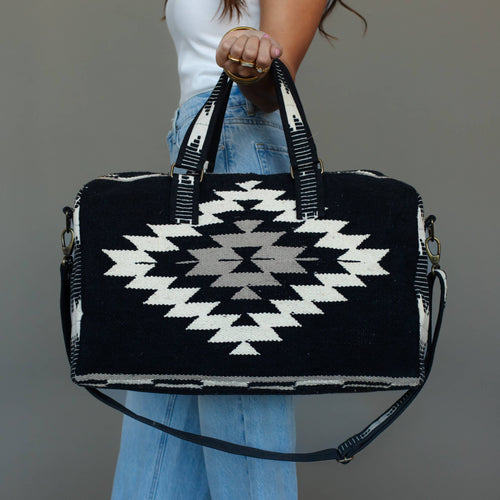 Black, white, and tan Western duffel with geometric pattern, woven cotton, and adjustable shoulder strap.