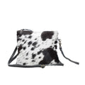 Black and white spotted cowhide bag with a zipper closure and adjustable crossbody strap. Casual and boho western style.