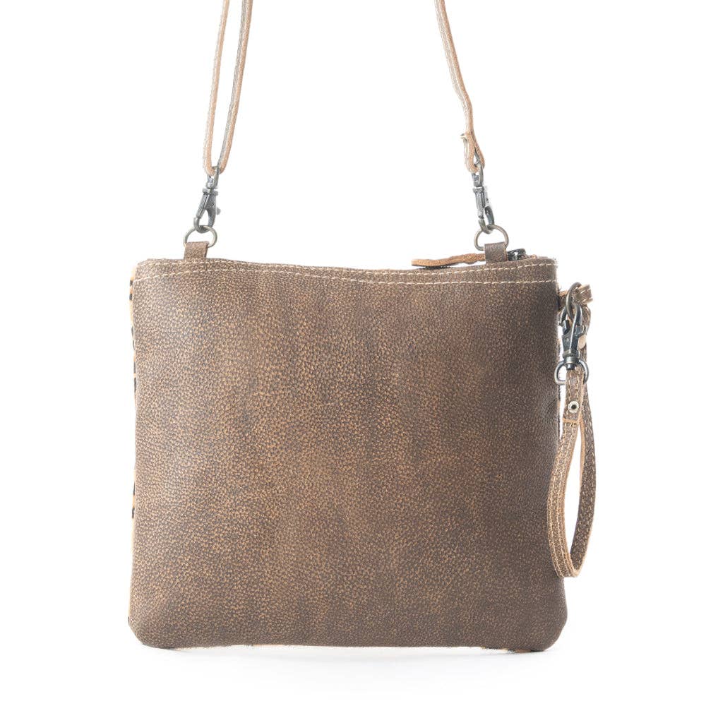 Freckled leather and hairon bag in leopard print with gold speckles, featuring a detachable strap and wrist handle.