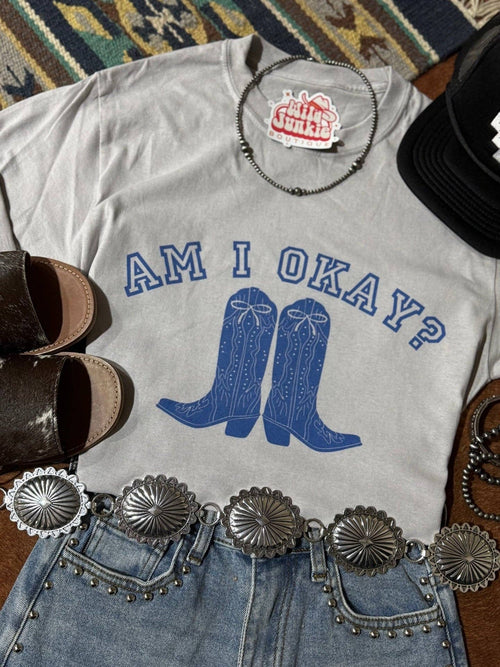 Am I Okay Graphic Tee with blue cowboy boots print, styled with studded denim shorts and silver concho belt.
