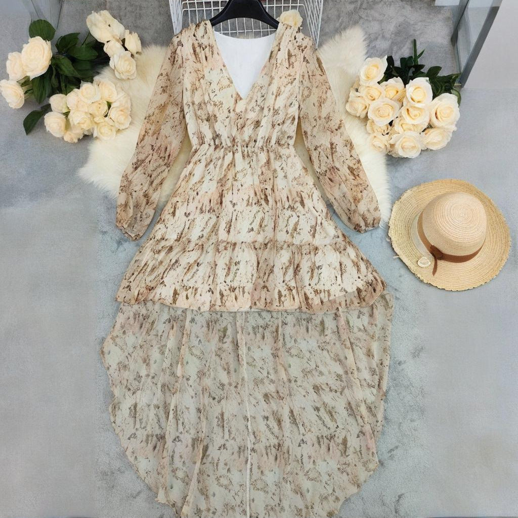 Bohemian V-neck long sleeve dress with an asymmetrical hem in a light beige and brown print, cinched waist for a flattering fit.