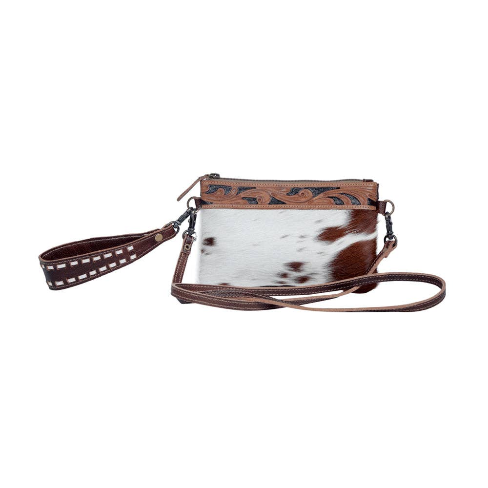 Chic hairon leather belt bag featuring a unique brown and white pattern, hand-tooled details, and dual strap options.