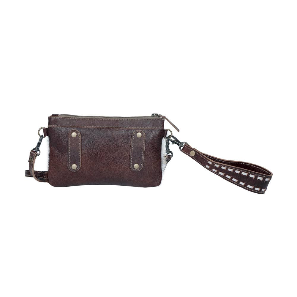 Brown hairon leather belt bag with hand-tooled detailing, dual straps, and zip closure. Styled as a wristlet.
