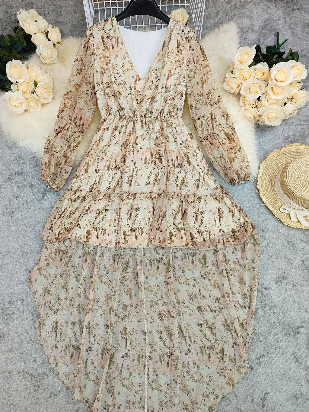 V-neck, layered bohemian dress in soft beige with floral print, featuring long sleeves and a flowy silhouette.
