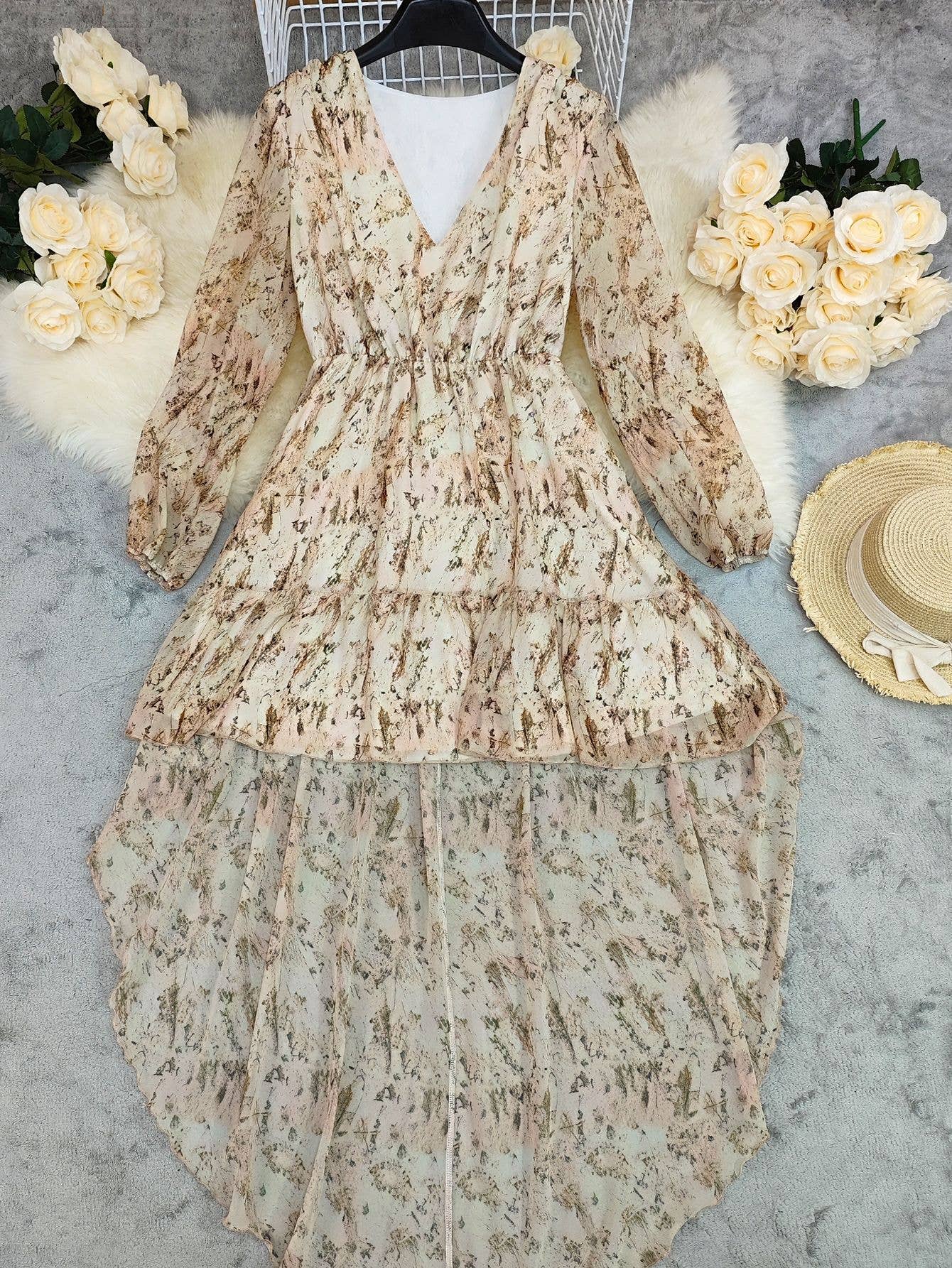 V-neck, layered bohemian dress in soft beige with floral print, featuring long sleeves and a flowy silhouette.