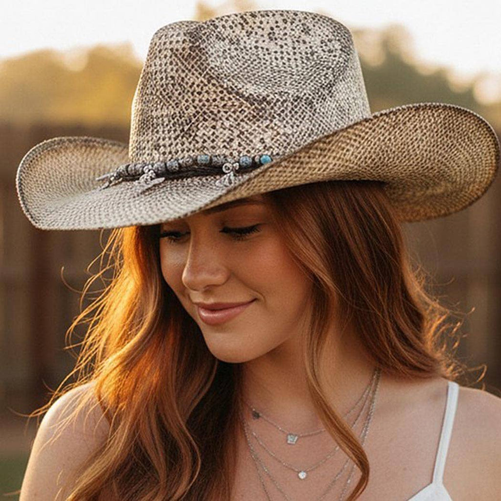 Handmade vintage cowboy hat in a textured beige weave, featuring a band with Western charms and a classic cowboy shape.
