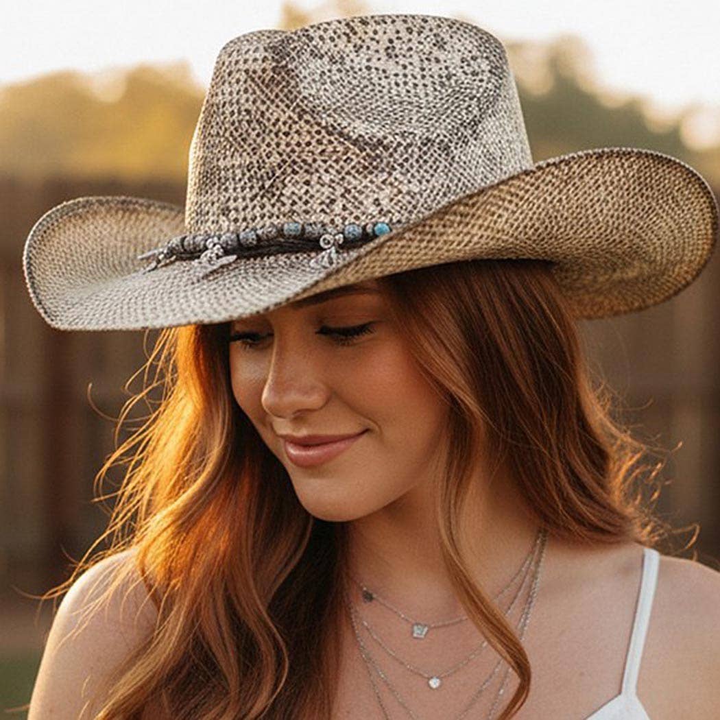 Handmade vintage cowboy hat in a textured beige weave, featuring a band with Western charms and a classic cowboy shape.