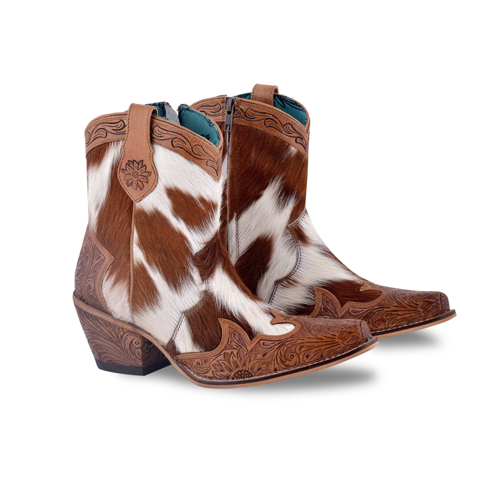 Hand-tooled leather boots featuring a hair-on hide design in brown and white. Snip toe with decorative engraving.