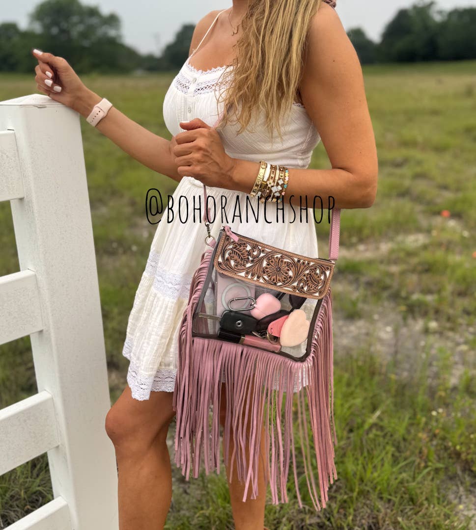 Hand tooled clear crossbody bag with pink fringe, featuring a decorative rose and secure snap closure. Suitable for stadium use.