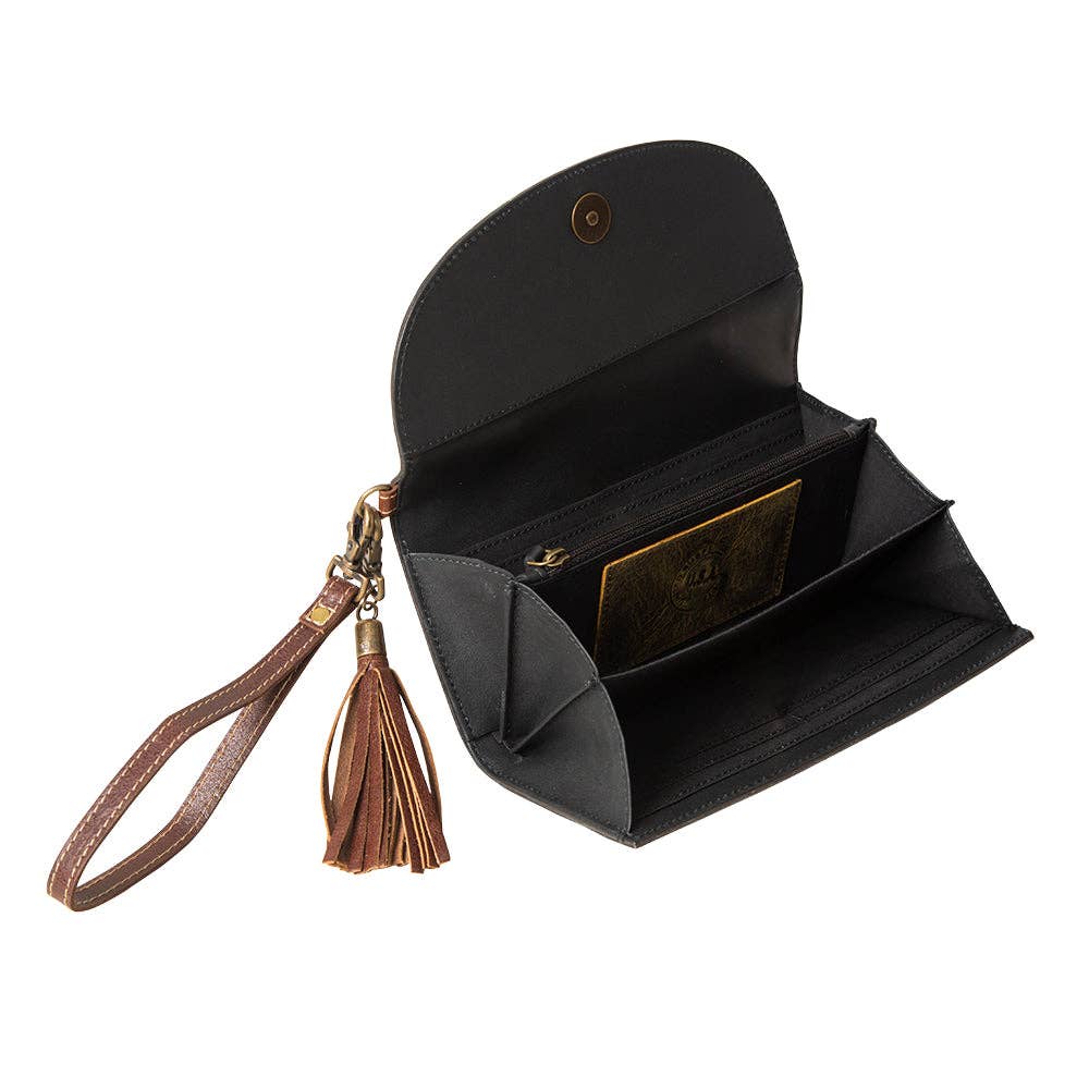 Hand-tooled leather wristlet wallet in black with hair-on cowhide. Features a snap front flap, tassel, and spacious interior.